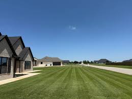 Wide view of manicured lawns in a Lawton, OK neighborhood under a clear blue sky